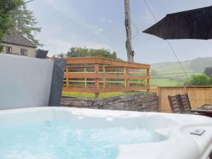 a bath tub on a patio with an umbrella at The Old Smithy in Llangunllo