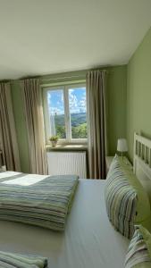 1 dormitorio con 2 camas y ventana en Waldgasthaus Balsamine, en Weimar