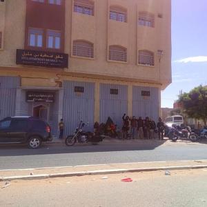 un gruppo di persone che si trovano fuori da un edificio di شقق فندقية بن خليل /hôtel appartements Bin khlil a Tan-Tan