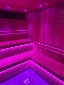 a purple room with benches in it with purple lights at Luxury Studios with Spa included in Portsmouth