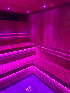 a purple room with benches in it with purple lights at Ashbys Deluxe Studios & Spa hire in Portsmouth