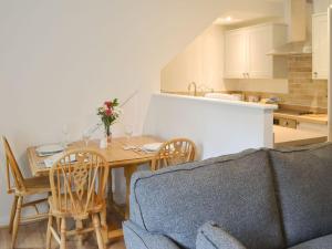 cocina y comedor con mesa y sillas en Thistle Cottage, en Glanton