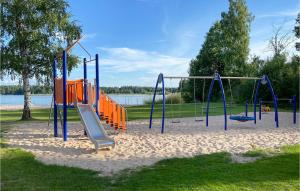 un parque infantil con un columpio naranja y azul en Amazing Home In deshg With Internet And 3 Bedrooms, en Ödeshög