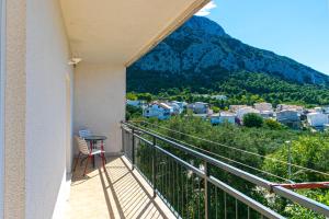 a balcony with a table and a view of a mountain at Apartments with a parking space Gradac, Makarska - 14708 in Gradac