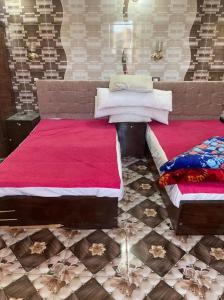 a bedroom with two beds with pink sheets at Nubian Dreams Guest House in Aswan