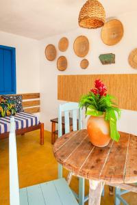 una habitación con una mesa con un jarrón encima en Pousada Bruma, en Caraíva