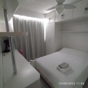 a white room with two beds and a ceiling fan at O melhor em Brasília - Sudoeste - Ville de France in Brasilia
