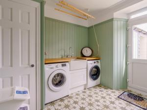 a washer and dryer in a green laundry room at Erriff At Caelaverock in Glencaple