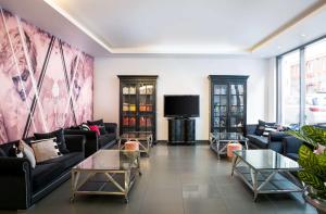 a living room with couches and a flat screen tv at elaya hotel vienna city west in Vienna