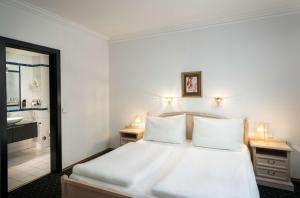 una camera da letto con un letto bianco e un bagno di Arthotel ANA Gala a Vienna