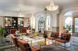 una hall con sedie, tavoli e lampadari a braccio di Arthotel ANA Gala a Vienna
