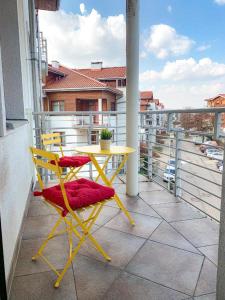 a yellow table and chairs on a balcony at Sailor Apartments - Neptun Park by OneApartments in Gdańsk