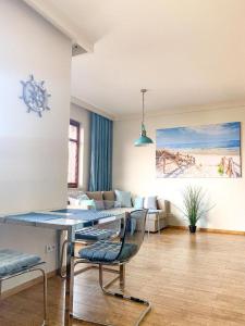 a living room with a table and chairs and a couch at Sailor Apartments - Neptun Park by OneApartments in Gdańsk