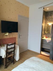 a bedroom with a bed and a table with a chair at Chez Pierrette in Pont-Croix