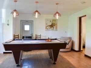 una mesa de billar en una sala de estar con luces colgantes en Wesley Old Hall House en Bacup