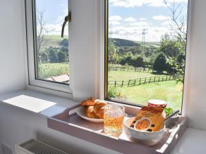 una ventana con un plato de comida en el alféizar de la ventana en Wesley Old Hall House, en Bacup