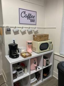 uma prateleira de cozinha com um micro-ondas e uma placa de café-bar em The Haven em Brookhaven