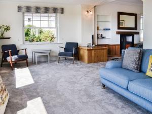 a living room with a blue couch and chairs at Repentance View in Carrutherstown