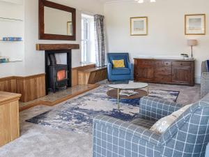 a living room with a blue couch and a fireplace at Repentance View in Carrutherstown