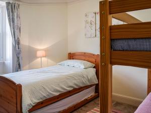 a bedroom with a bunk bed and a lamp at Repentance View in Carrutherstown