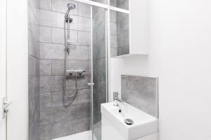 a white bathroom with a shower and a sink at Hagley Road Apartments - Self Contained Entire Apartments with Kitchen & Netflix - Birmingham City Centre in Birmingham