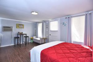 um quarto com uma cama com um cobertor vermelho em BLUE FLAMINGO'S ADORABLE GUEST HOUSE -TU-Cherry St-Expo-Downtown-11t em Tulsa