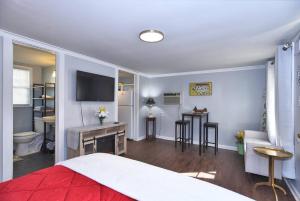 a bedroom with a bed and a desk with a television at BLUE FLAMINGO'S ADORABLE GUEST HOUSE -TU-Cherry St-Expo-Downtown-11t in Tulsa