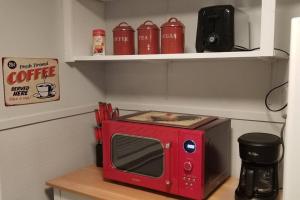 a red microwave sitting on top of a table at BLUE FLAMINGO'S ADORABLE GUEST HOUSE -TU-Cherry St-Expo-Downtown-11t in Tulsa