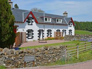 una casa bianca con un muro di pietra davanti di Uk35715 - South Cottage a Teviothead