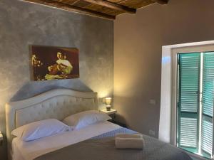 una camera da letto con un letto e un dipinto sul muro di il Caravaggio b&b a Caprarola