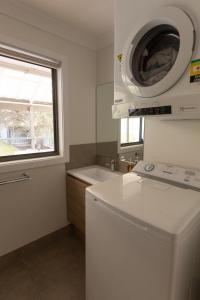 a kitchen with a washing machine and a window at Bay Dream Believer, Ample Boat Parking, Pet Friendly 4 br Holiday House Shoal Bay in Shoal Bay