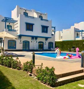 un gran edificio blanco con una piscina frente a él en Luxury Villa with pool in Hurghada, en Hurghada