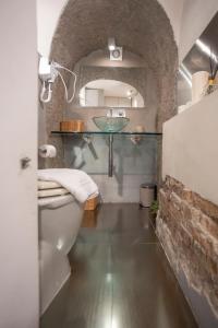 La salle de bains est pourvue de toilettes blanches et d'un lavabo. dans l'établissement Domus Ciancaleoni - Colosseum - Rione Monti, à Rome