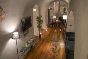 een woonkamer met een bank, een televisie en een tafel bij Domus Ciancaleoni - Colosseum - Rione Monti in Rome