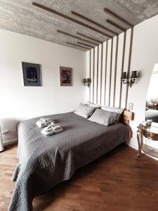 a bedroom with a large bed with a gray blanket at Cozy Studio in Palanga City Center in Palanga