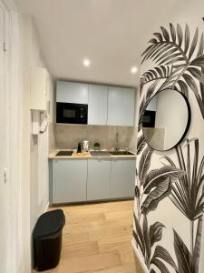 a kitchen with white cabinets and a black and white plant at Hyper centre idéal gare Amiens in Amiens