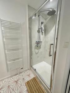 La salle de bains est pourvue d'une douche avec une porte en verre. dans l'établissement Hyper centre idéal gare Amiens, à Amiens