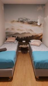dwa łóżka w pokoju z obrazem na ścianie w obiekcie APARTAMENTY MONTANIA WISŁA w Wiśle