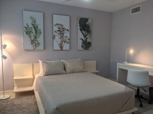 a bedroom with a bed and three pictures on the wall at Clematis House near Arlington Park with Heated Pool in Sarasota +23 photos