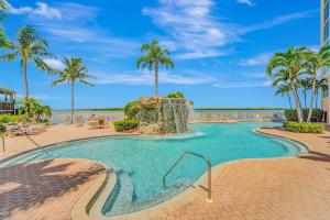a swimming pool at a resort with palm trees at Tropical Paradise in Fort Myers Beach