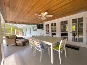 een eettafel met stoelen en een plafondventilator bij Clematis House near Arlington Park with Heated Pool in Sarasota