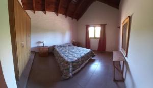 a small bedroom with a bed and a window at Cabañas De Cara al Sol in Villa Giardino