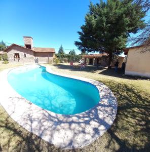 a swimming pool in the yard of a house at Cabañas De Cara al Sol in Villa Giardino