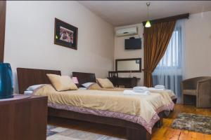 um quarto de hotel com duas camas e uma televisão em Garni Hotel City em Kruševac