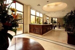 un vestíbulo con escritorio y algunas plantas y ventanas en Long Stay Alvorada 1009 aparthotel 2 dorms Vila Olímpia, en São Paulo