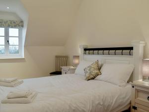 Schlafzimmer mit einem großen weißen Bett und einem Fenster in der Unterkunft The New Inn Barn-uk31813 in Marnhull