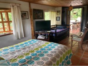 Schlafzimmer mit einem Bett und einem Flachbild-TV in der Unterkunft Mirador de los Vientos in Manizales