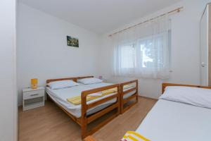 una camera con due letti e una finestra di Apartments with a parking space Gradac, Makarska - 5198 a Gradac (Grado)