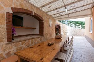una sala da pranzo con tavolo in legno e parete in pietra di Apartments with a parking space Gradac, Makarska - 5198 a Gradac (Grado)