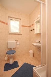 a bathroom with a toilet and a sink at Apartments with a parking space Seget Vranjica, Trogir - 8507 in Seget Vranjica